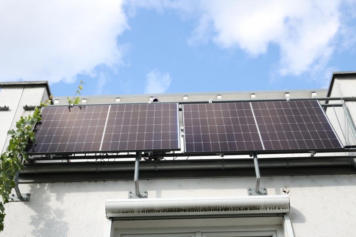 Balkonkraftwerk bestehend aus zwei Solarmodulen hängt am Balkongeländer.